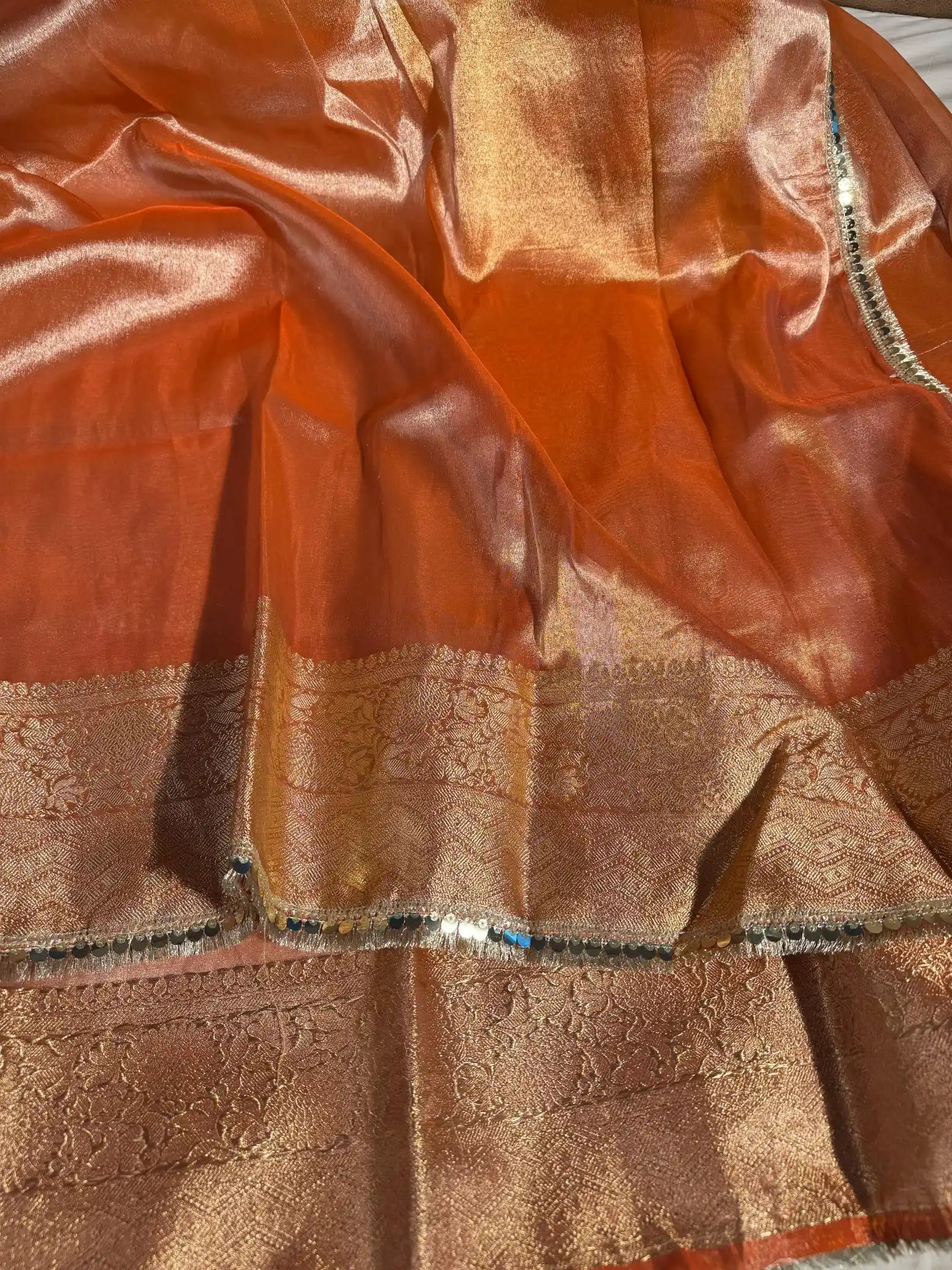 Metallic Orange Glass Tissue Silk Banarasi Saree with Intricate Floral Borders and Pretty Lace Work